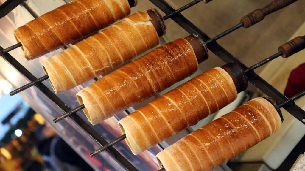 Kürtőskalács is made from sweet, raised dough (raised by yeast), which is then spun into a strip and wrapped around a cone-shaped baking spit, and rolled in sugar.